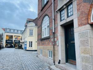 a cobblestone street next to a brick building at Studio Apartment in the heart of Aalborg in Aalborg