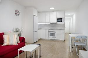 a living room with a red couch and a kitchen at Casa Joyne in Puerto del Carmen