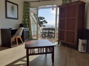 a living room with a coffee table and a piano at TROPIC Appartements PREMIUM village vacances vue mer Guadeloupe St Anne in Sainte-Anne +115 photos