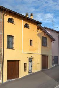 un bâtiment jaune avec deux portes de garage dans une rue dans l'établissement Il Falco, à Castellarano