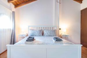 - une chambre avec un lit blanc et 2 tables de chevet dans l'établissement Il Falco, à Castellarano