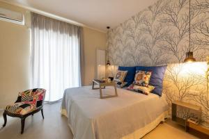 a bedroom with a large bed and a chair at Charming luxury apartment: Sorrento center in Sorrento