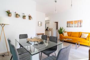 a dining room with a glass table and chairs at Tetuán Olehousing in Seville