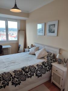 1 dormitorio con 1 cama con colcha en blanco y negro en Piso Prol, en Ourense