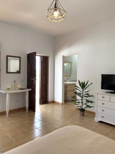 een grote woonkamer met een tafel en een televisie bij Casa Jasmin Haria in Haría