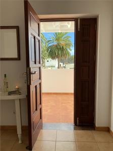 een open deur naar een kamer met een palmboom bij Casa Jasmin Haria in Haría