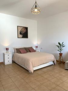 a bedroom with a large bed and a potted plant at Casa Jasmin Haria in Haría