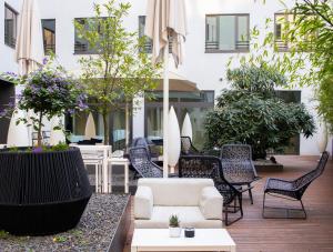 een patio met stoelen en tafels en een gebouw bij SANA Berlin Residence in Berlijn