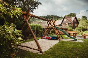 a playground with a swing set in a yard at Penzion Na Fojtství in Zašová