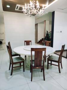 una sala da pranzo con tavolo e sedie bianchi di Bungalow cheras hijauan residence HomeStay 6 bedrooms a Cheras