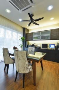 a dining room table with two chairs and a ceiling fan at Bungalow cheras hijauan residence HomeStay 6 bedrooms in Cheras