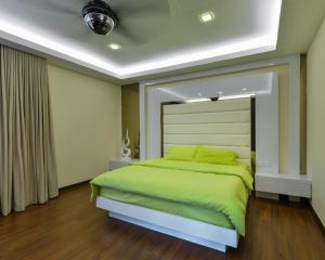 a bedroom with a green bed in a room at Bungalow cheras hijauan residence HomeStay 6 bedrooms in Cheras