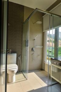 a bathroom with a toilet and a glass shower at Bungalow cheras hijauan residence HomeStay 6 bedrooms in Cheras