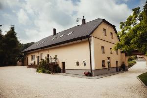 a large white building with a black roof at Penzion Na Fojtství in Zašová