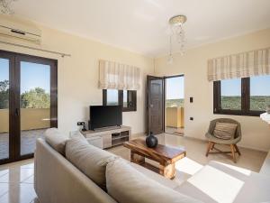 un soggiorno con divano e TV di Villa Hibiscus a Spiliá