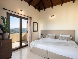 a bedroom with a large bed and a large window at Villa Hibiscus in Spiliá