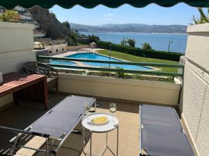 een tafel en stoelen op een balkon met een zwembad bij Residencial Vistamar in Santoña