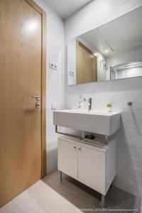 ein Badezimmer mit einem weißen Waschbecken und einem Spiegel in der Unterkunft Flateli Navas D01 in Barcelona
