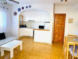 een woonkamer met een bank en een tafel en een keuken bij Bungalow en Arenales del Sol in Arenales del Sol