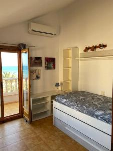 a bedroom with a bed and a view of the ocean at Bungalow en Arenales del Sol in Arenales del Sol