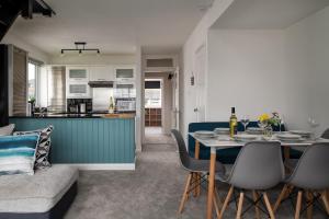 a dining room and kitchen with a table and chairs at Rivage - Modern Maisonette in Deganwy