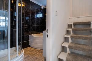 a bathroom with a walk in shower next to a glass door at Rivage - Modern Maisonette in Deganwy