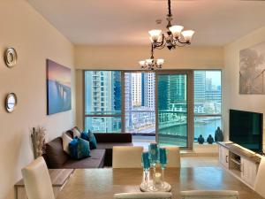 a living room with a table and a large window at White Sage - Marina Gem, Fancy Apartment with Waterfront Views in Dubai
