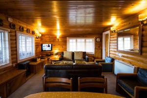 a living room with a couch and a tv in a log cabin at Mountain View Log Cabin - Wales in Trawsfynydd