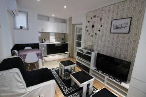 a living room with a couch and a tv at Dučić Apartment in Trebinje