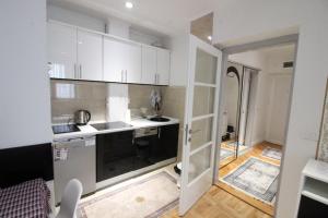 cocina con armarios blancos y puerta abierta en Dučić Apartment, en Trebinje