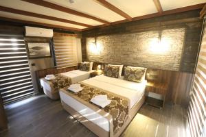 1 dormitorio con 2 camas y pared de ladrillo en SARIGERME NEW GATE HOTEL, en Sarigerme