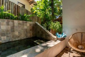 eine Terrasse mit einem Teich, einem Stuhl und einem Zaun in der Unterkunft DA GRAÇA HOTEL in Trancoso