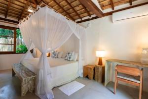 a bedroom with a bed with mosquito net at DA GRAÇA HOTEL in Trancoso