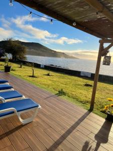 un gruppo di sedie a sdraio su una terrazza vicino all'acqua di Azores 5 estrelas a Porto Judeu