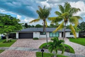 uma casa com palmeiras em frente em Sandals Beach Cottage em Fort Lauderdale