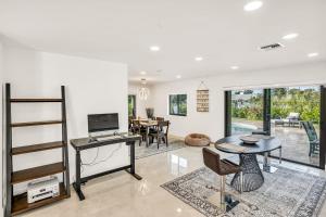 ein offenes Wohnzimmer mit Schreibtisch und Tisch in der Unterkunft Sandals Beach Cottage in Fort Lauderdale
