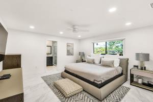 ein weißes Schlafzimmer mit einem Bett und einem Teppich in der Unterkunft Sandals Beach Cottage in Fort Lauderdale + 39 Fotos