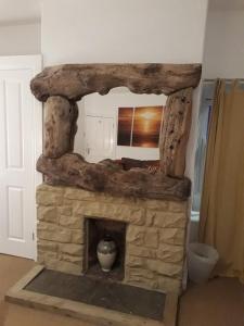una chimenea de piedra con un jarrón encima en The Sun Rooms, en Alnmouth