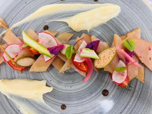 een bord met groenten en saus erop bij Auberge Le Meisenberg in Châtenois