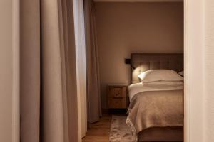um quarto com uma cama e uma mesa de cabeceira ao lado de uma cama sidx sidx sidx em TOP Hotel Hochgurgl em Hochgurgl