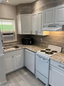 a kitchen with white cabinets and a stove top oven at Expo Motel in Hollywood