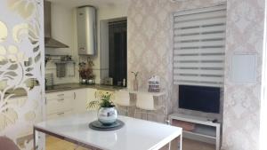 Il comprend une cuisine avec une table blanche et une télévision. dans l'établissement Apartamento Los Padrinos, à Cordoue 4 autres photos