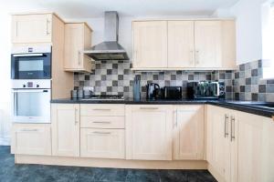 una cocina con armarios blancos y encimeras negras en Emerald House Leisure & Contractors en Peterborough