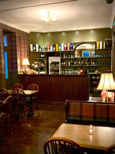 a restaurant with tables and chairs and a bar at Strathardle Lodge in Kirkmichael