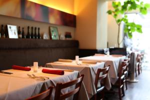 a row of tables in a restaurant with red napkins at KOKO HOTEL Numazu Ekimae in Numazu +18 photos