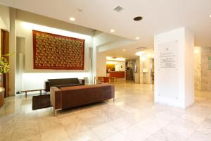 a lobby with a couch and a painting on the wall at KOKO HOTEL Numazu Ekimae in Numazu
