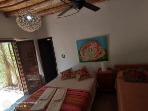 ビヤ・ウニオンにあるChakana Hospedaje Ruralのベッドルーム1室(ベッド1台、椅子2脚、シャンデリア付)