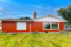 una casa rossa con un prato davanti di The Bluff Cottage a Port Angeles