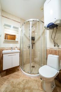 a bathroom with a shower and a toilet and a sink at Cozy Stay 2bdrm Central Apartment in Varna City