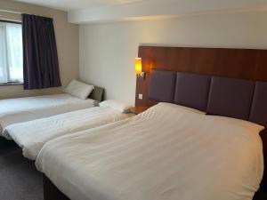 a hotel room with two beds and a window at Cat & Lion Country Pub and Hotel in Warrington